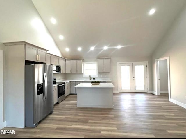 kitchen featuring light wood-type flooring, gray cabinetry, stainless steel appliances, sink, and a kitchen island