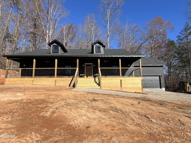 country-style home featuring a porch and a garage