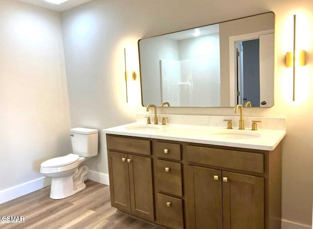 bathroom with hardwood / wood-style flooring, vanity, and toilet