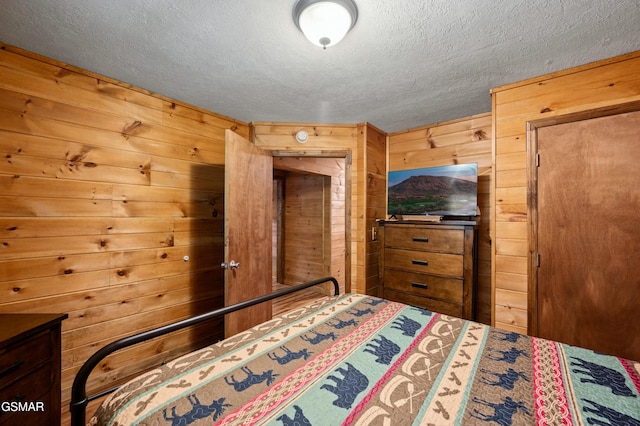 unfurnished bedroom with wooden walls and a textured ceiling