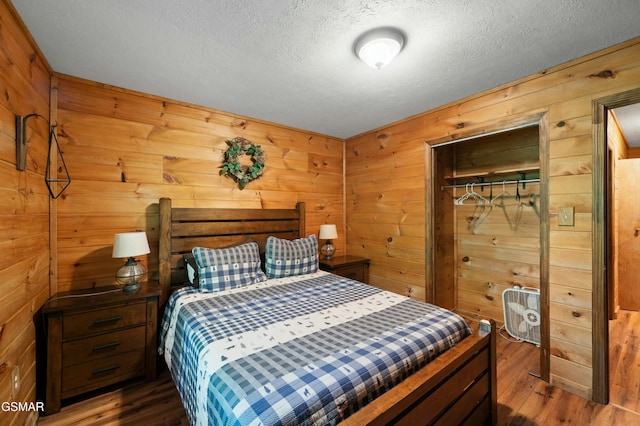 bedroom with dark hardwood / wood-style floors and wood walls