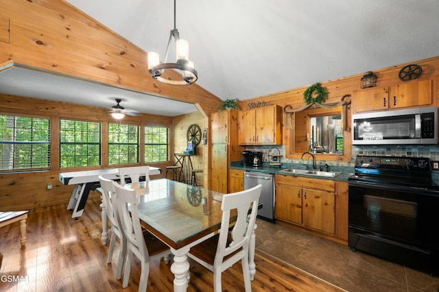 kitchen with lofted ceiling, sink, decorative light fixtures, appliances with stainless steel finishes, and decorative backsplash