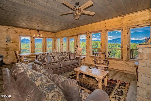 living room with ceiling fan, wood finished floors, wood ceiling, and wood walls