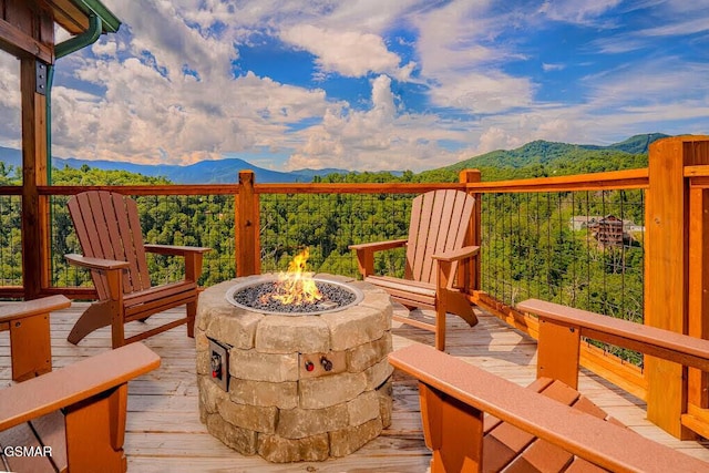 exterior space with a deck with mountain view and a fire pit