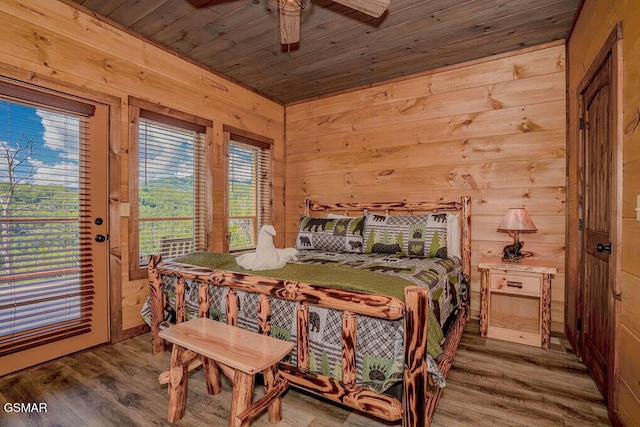 bedroom with access to exterior, wooden ceiling, wooden walls, wood finished floors, and ceiling fan