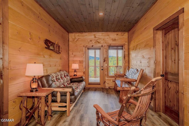 sitting room featuring wood finished floors, wooden walls, and wooden ceiling