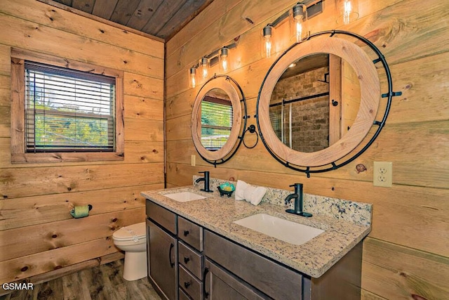full bathroom featuring toilet, a sink, and wood walls