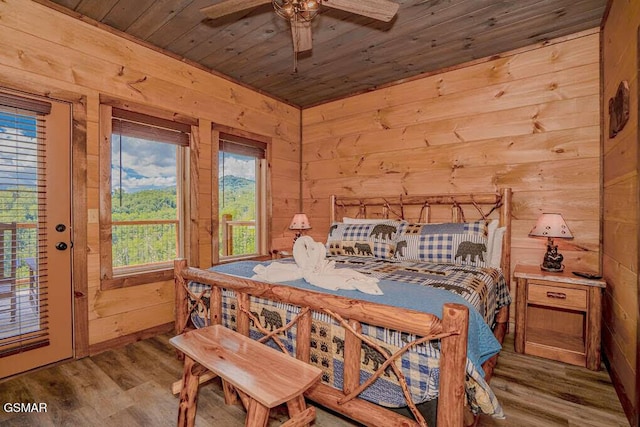bedroom with wood ceiling, wood walls, access to outside, and wood finished floors