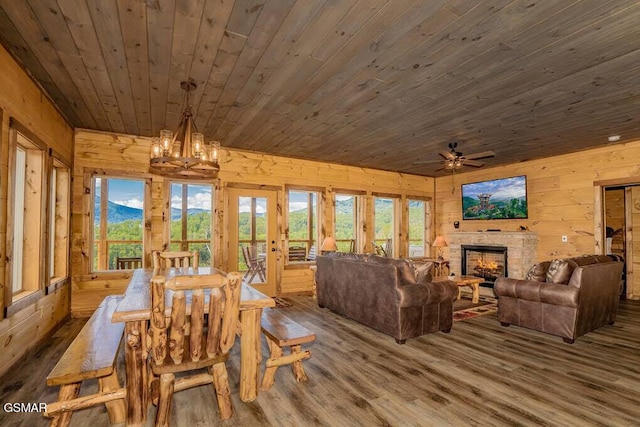 dining area with wooden walls, wood finished floors, wood ceiling, and a healthy amount of sunlight