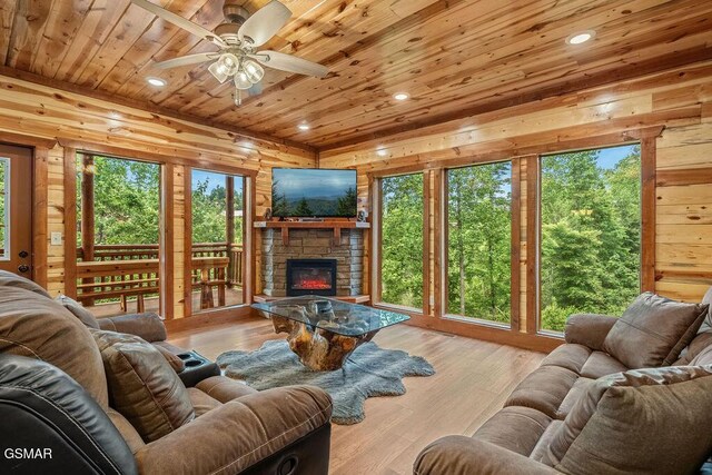 2864 Owens Ridge Way, Sevierville, TN 37876 - living room with wood ceiling, a stone fireplace, ceiling fan, healthy amount of natural light, and wooden walls