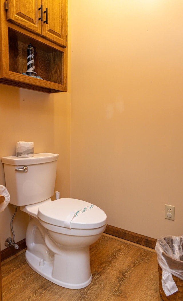 bathroom with hardwood / wood-style flooring and toilet