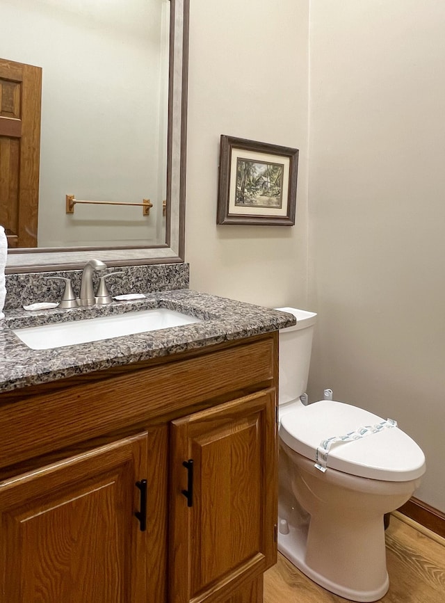 bathroom featuring vanity, hardwood / wood-style flooring, and toilet