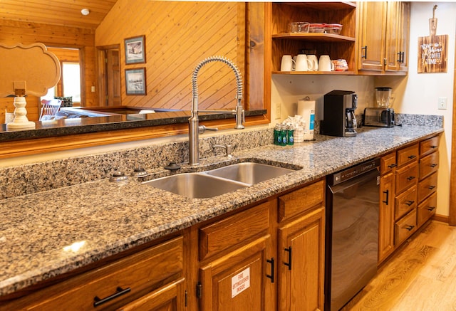 kitchen with light stone countertops, vaulted ceiling, sink, light hardwood / wood-style flooring, and dishwasher