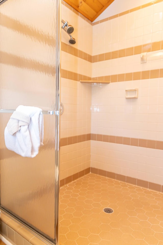 bathroom featuring walk in shower and vaulted ceiling