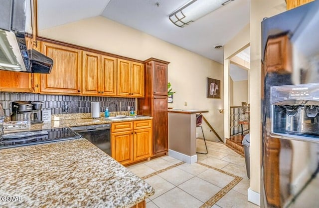 kitchen featuring light stone countertops, sink, backsplash, and black appliances