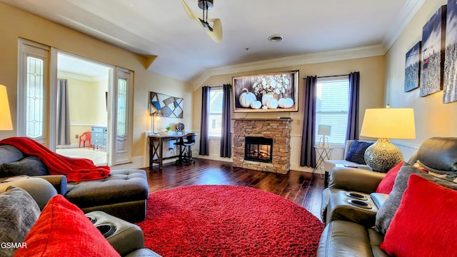 living room with ornamental molding, a stone fireplace, and dark hardwood / wood-style flooring