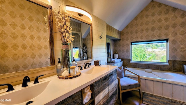 bathroom featuring vanity, vaulted ceiling, and a tub