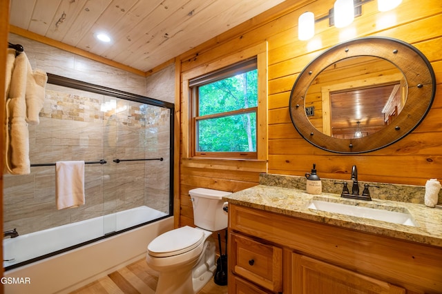 full bathroom featuring wooden ceiling, bath / shower combo with glass door, wood-type flooring, toilet, and wooden walls