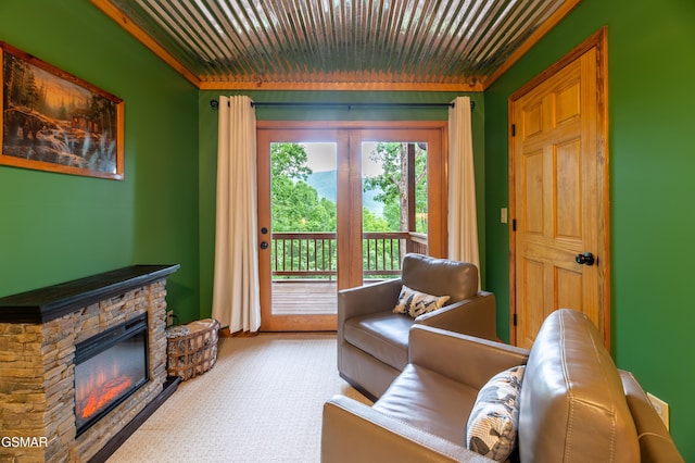 living room featuring a stone fireplace and ornamental molding