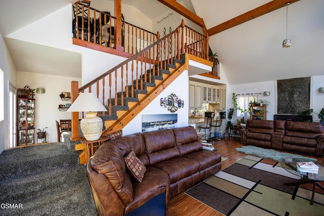 living room featuring beamed ceiling, wood-type flooring, and high vaulted ceiling