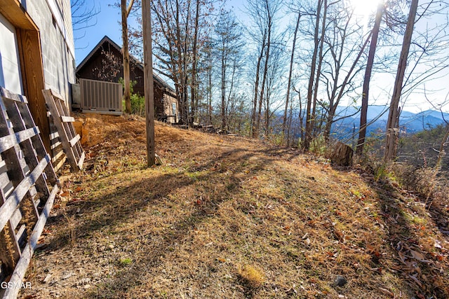 view of yard with a mountain view and central AC unit