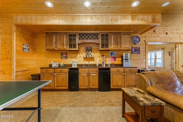 kitchen with dark countertops, wood walls, glass insert cabinets, and brown cabinets