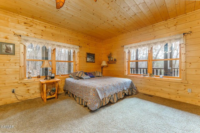 carpeted bedroom with wood walls, wood ceiling, and visible vents