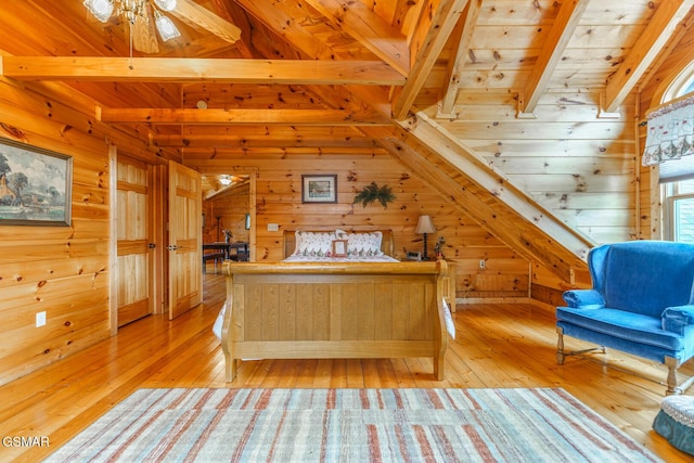 unfurnished bedroom featuring wood walls, light wood-style floors, and beam ceiling