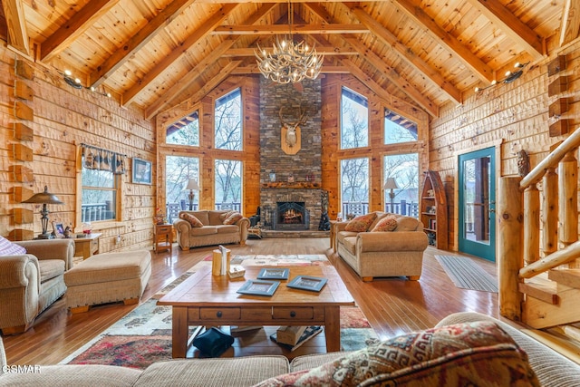 living area featuring wood ceiling, a healthy amount of sunlight, a stone fireplace, and hardwood / wood-style floors