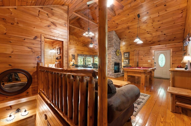 living area with wood walls, billiards, wood ceiling, a ceiling fan, and high vaulted ceiling