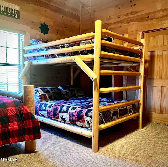 carpeted bedroom featuring wooden walls