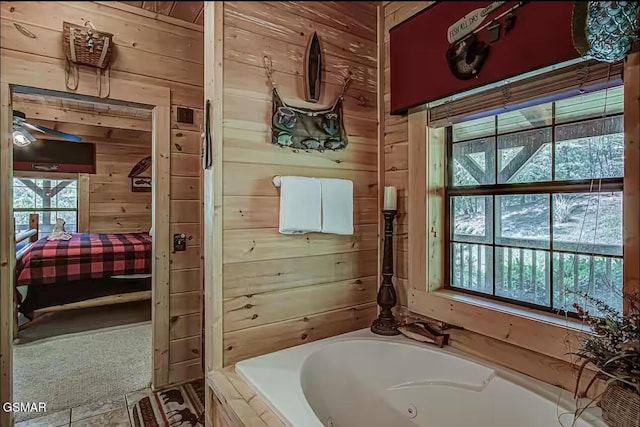 bathroom featuring wood walls, a jetted tub, and ensuite bathroom