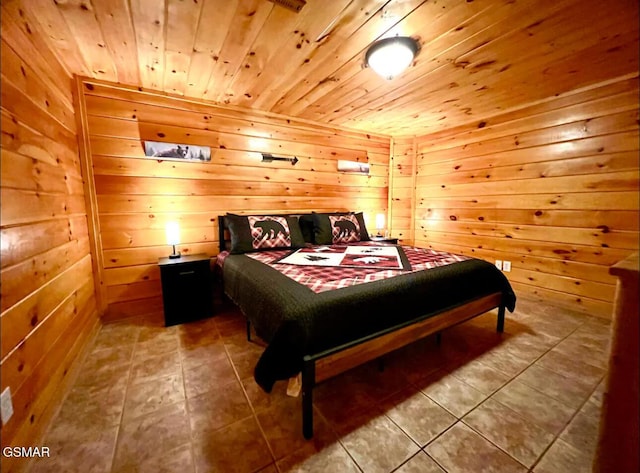 bedroom with wood ceiling, tile patterned floors, and wood walls