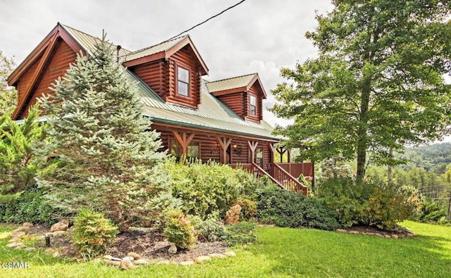rear view of house featuring log siding, a porch, a yard, stairs, and metal roof