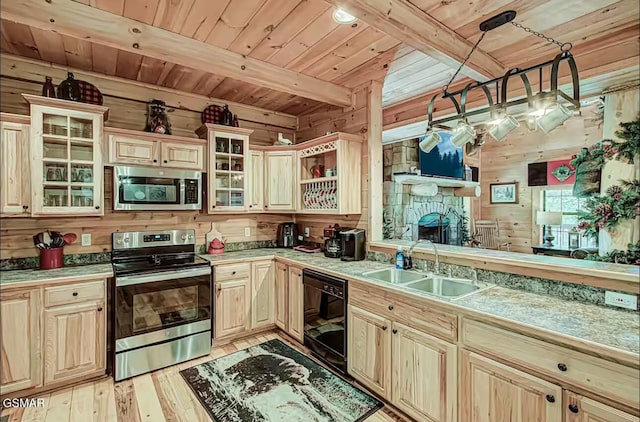 kitchen featuring stainless steel appliances, wooden walls, a sink, wooden ceiling with exposed beams, and light wood-style flooring