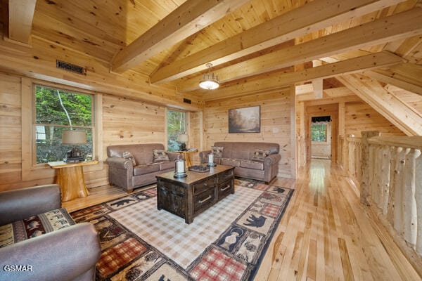 living area with wooden walls, wooden ceiling, light wood-type flooring, and beam ceiling