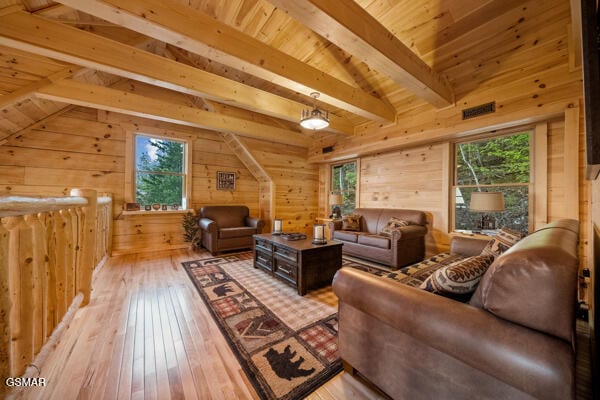 living area featuring wooden walls, plenty of natural light, and wood-type flooring