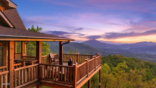 deck at dusk featuring a mountain view