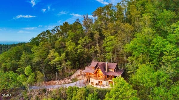 drone / aerial view featuring a wooded view