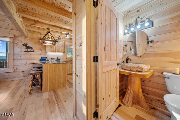 bathroom featuring wooden walls, wooden ceiling, wood-type flooring, and toilet