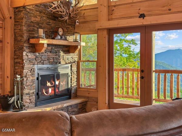 living area with a stone fireplace and a mountain view