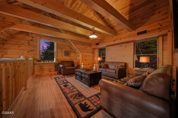 living area with vaulted ceiling with beams, wooden walls, hardwood / wood-style flooring, and wooden ceiling
