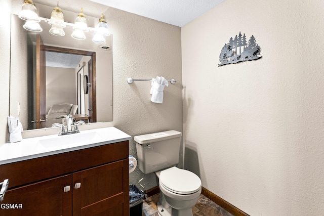 bathroom featuring toilet, vanity, and a textured ceiling