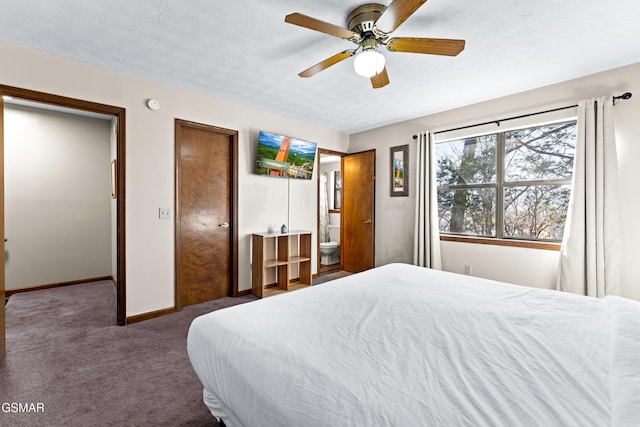 bedroom with a textured ceiling, ceiling fan, ensuite bathroom, and dark colored carpet