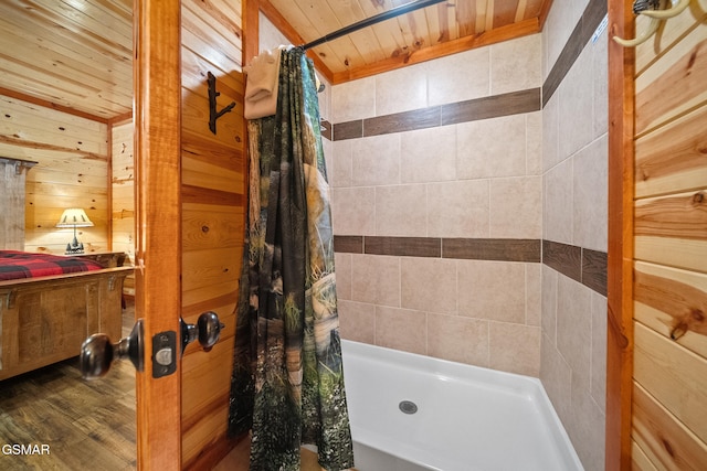 bathroom featuring wood ceiling, wood walls, tiled shower, and wood finished floors