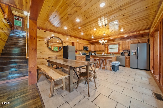 dining space with wood ceiling, stairs, a chandelier, wooden walls, and recessed lighting