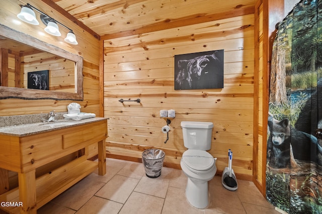 bathroom with tile patterned flooring, wood walls, wooden ceiling, vanity, and toilet