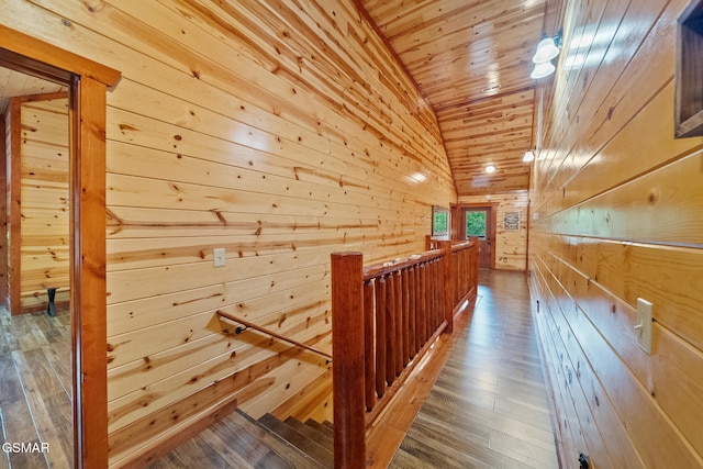 hallway featuring wood walls, hardwood / wood-style floors, an upstairs landing, wooden ceiling, and lofted ceiling