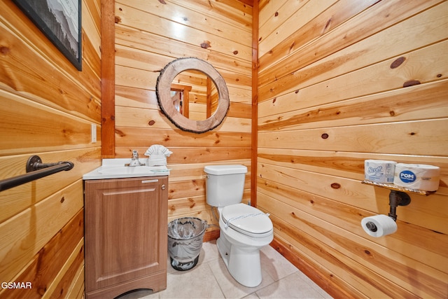 bathroom featuring wood walls, tile patterned floors, and toilet