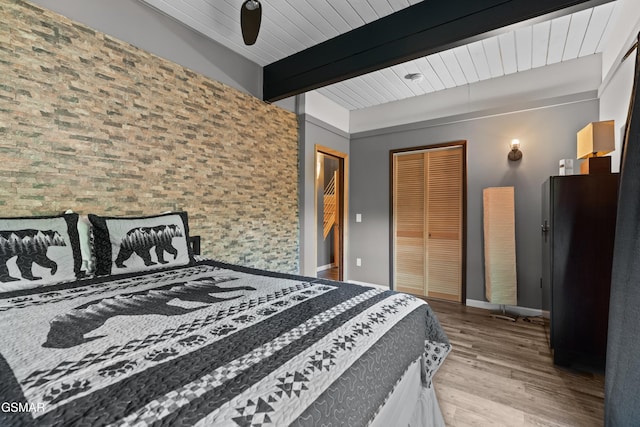 bedroom with beam ceiling and light wood-type flooring